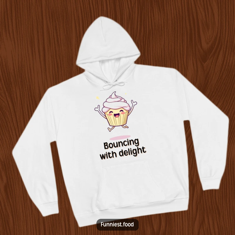 Funny hooded sweatshirt depicting a joyful cupcake character in a celebratory jump, blending comfort and festive cheer.